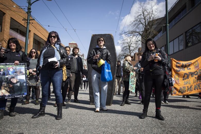 People march in the street holding signs.