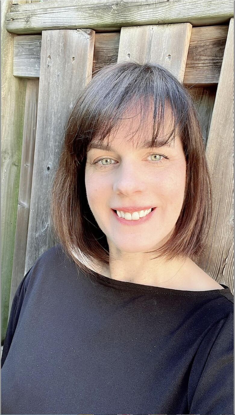 A photo of a woman with brown hair smiling.