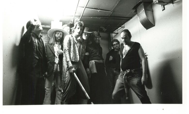 A black and white photograph of eight men posing for a picture.