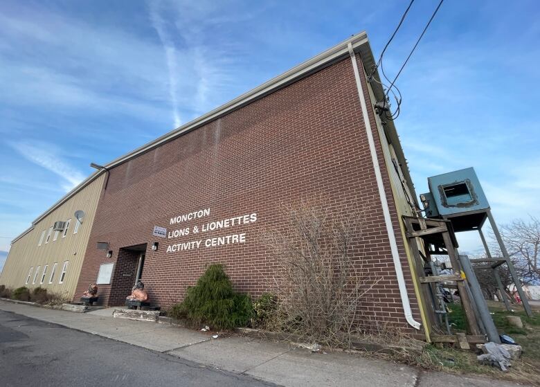 A two-storey building with red brick and beige metal on its exterior. 