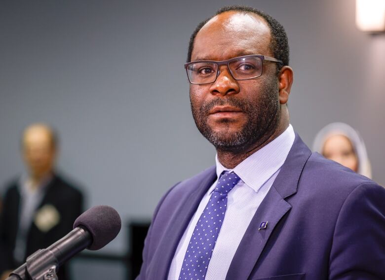 A man wearing glasses looks at the camera.