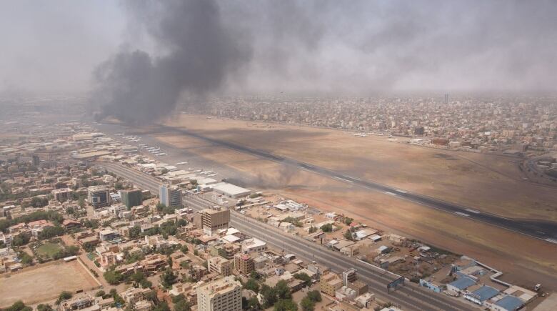 A cloud of smoke is shown billowing over a city.