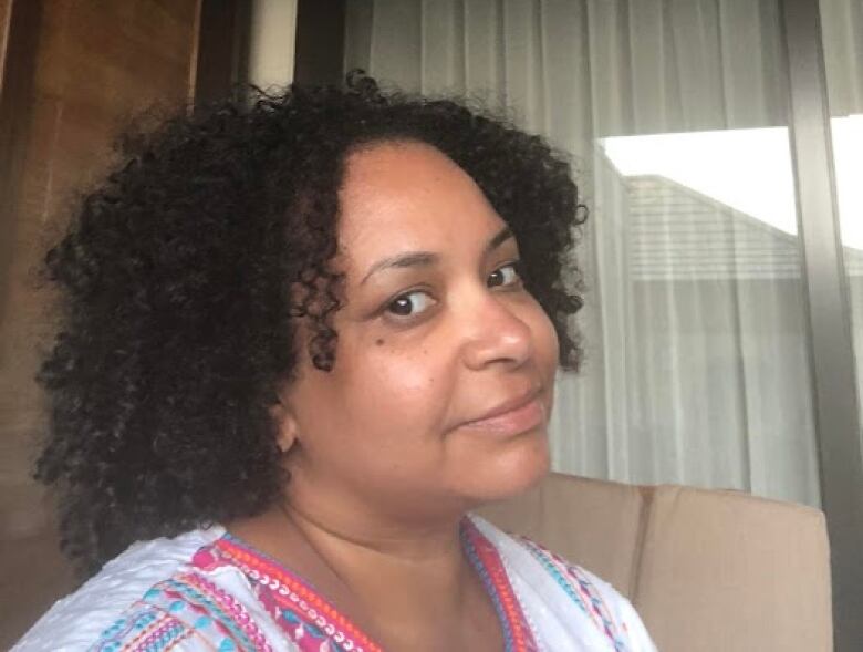 Selfie of a woman with curly black hair.