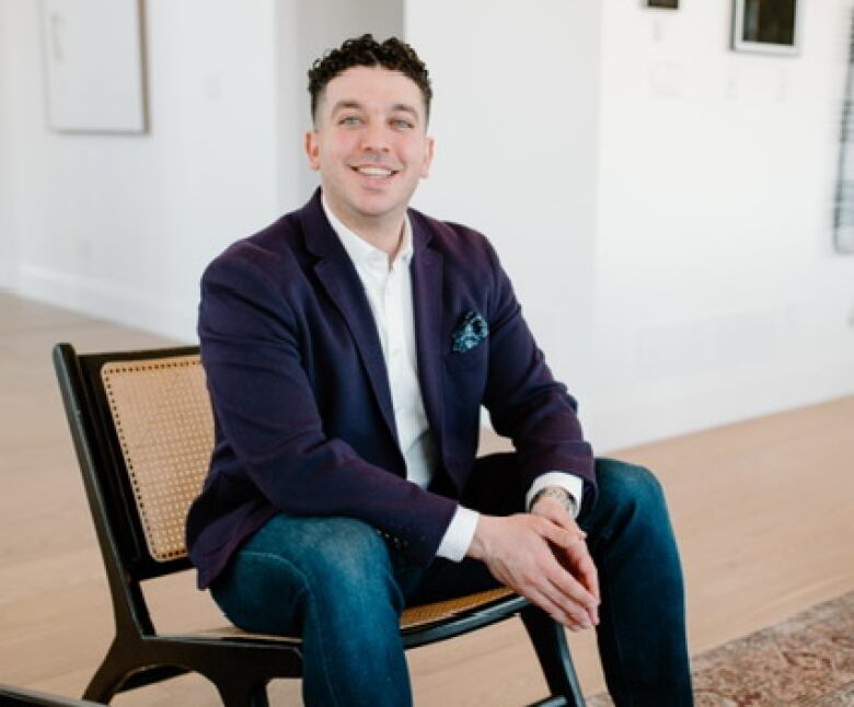 A young man sits in a nice home. 