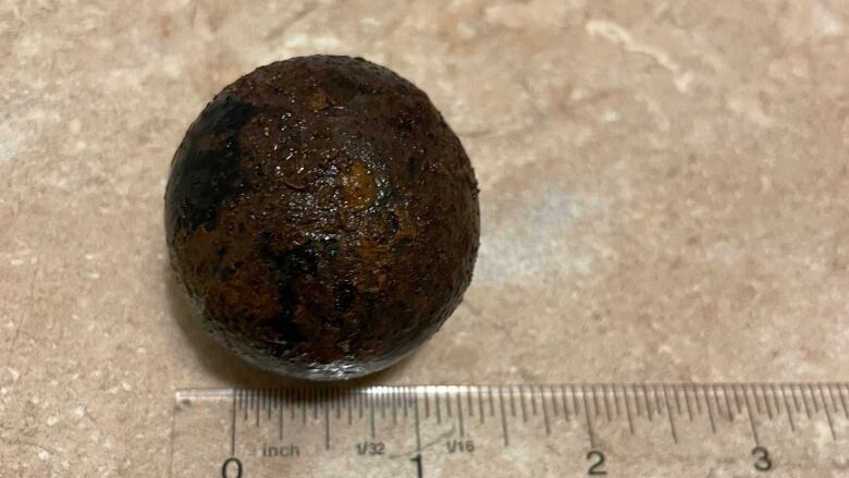 A small cannonball measured against a ruler