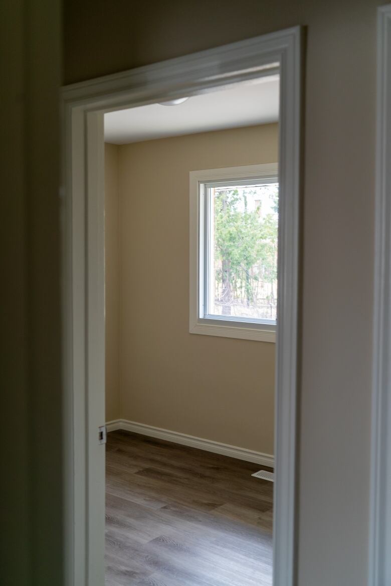 An empty bedroom seen from a hallway.