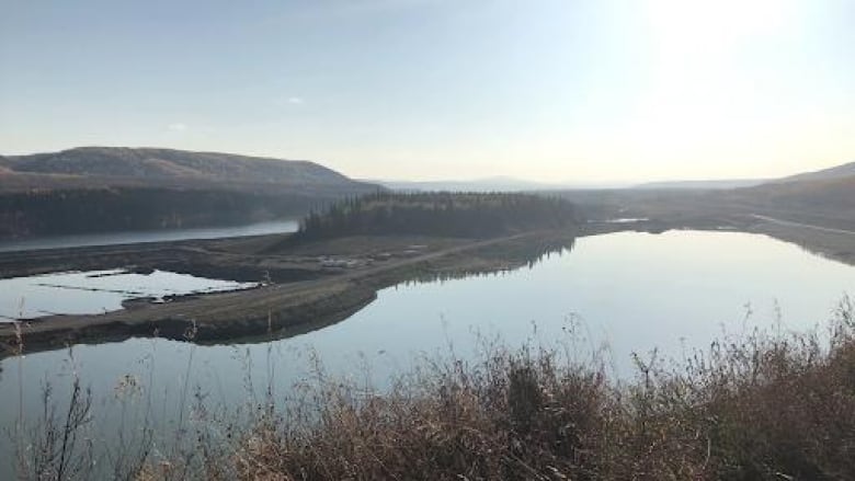 A river winds through marsh and low hills.