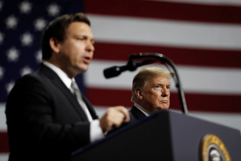 Donald Trump and Ron DeSantis near each other on a stage. 