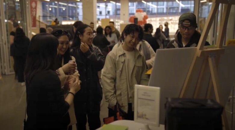 Five young Calgarians look at a board in the library during an event