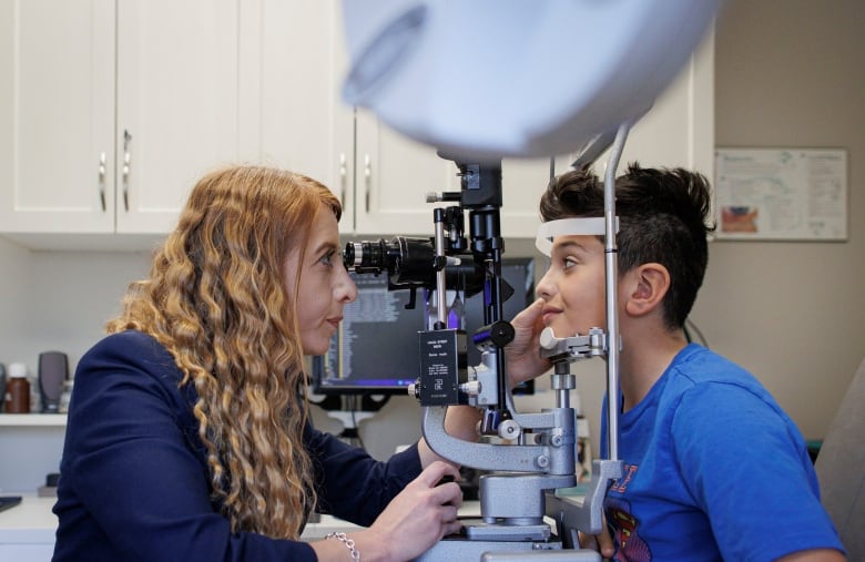 An eye specialist gives a child an exam in her office in North York.