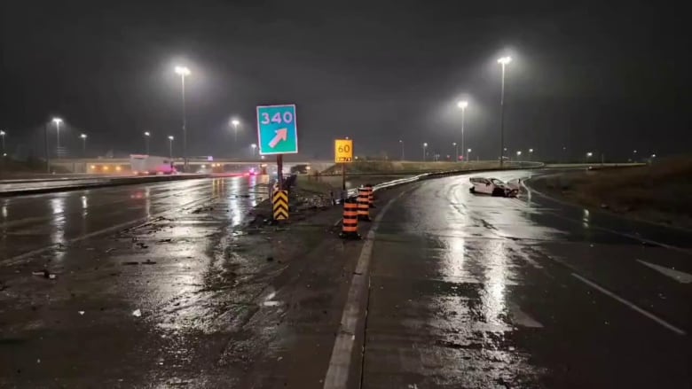 A white car can be seen crashed into a highway guard rail in the distance.