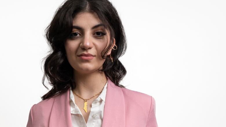 Aman Ghawanmeh in a pink suit looking at the camera with a determined facial expression