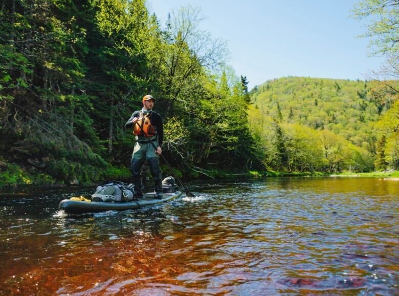 Lee Fraser on a stand up paddle board in the Margaree River