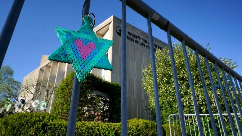 A building is shown behind an iron fence.