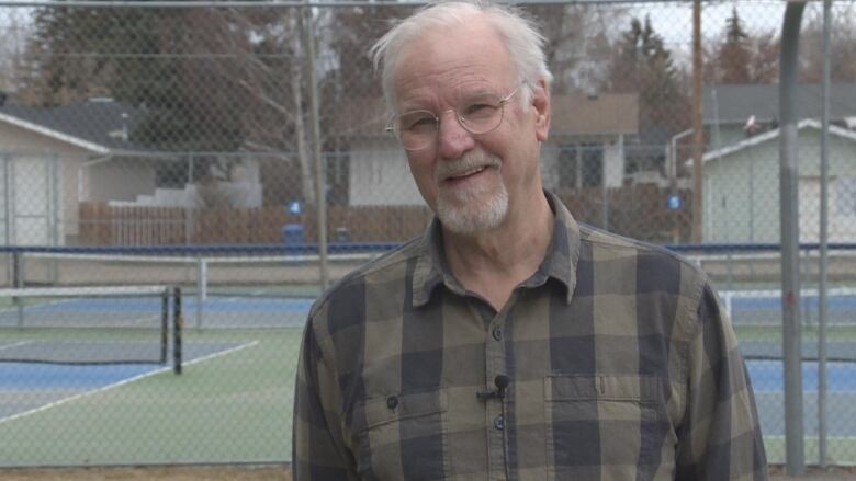 A man is pictured. He has white hair and a white beard.