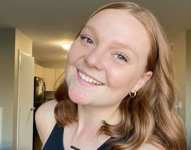 A woman smiles while posing for a photo.