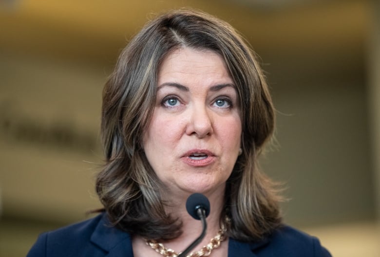 A woman speaks in front of a podium.