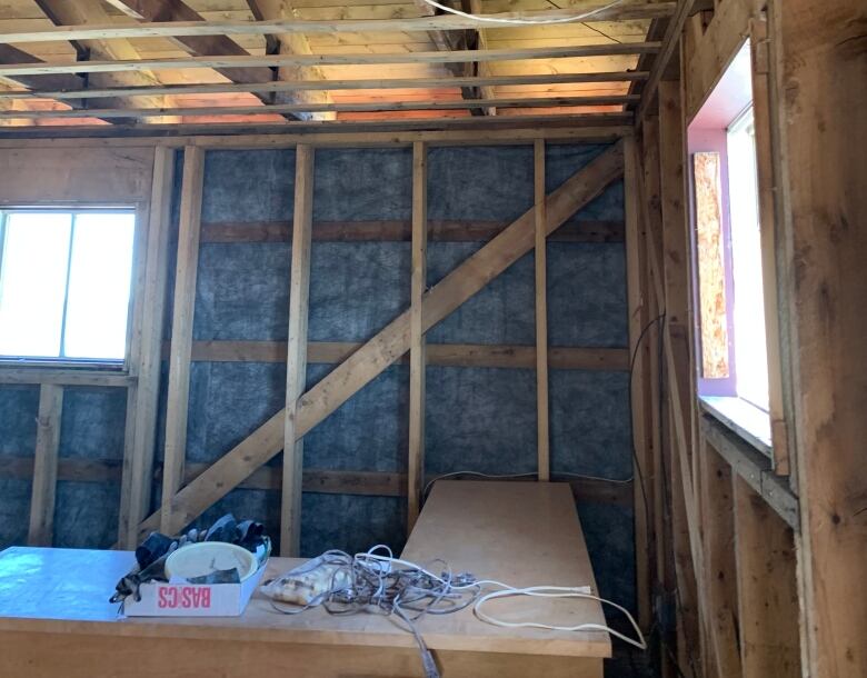 Wooden framing of a room in seen, as well as insulation.