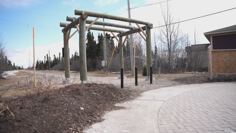 A wooden archway marks the start of the trail. There are no visible benches in the area. 