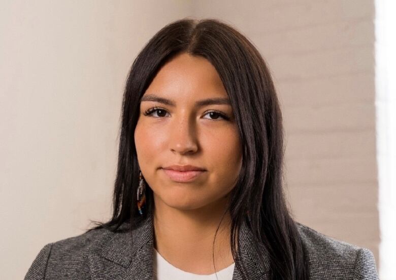 A young woman with long hair smiles.