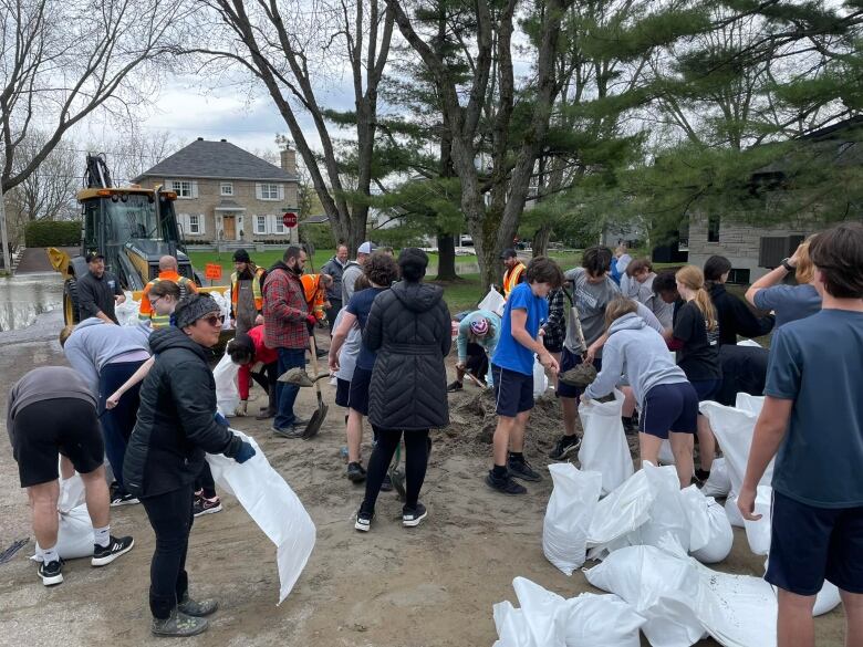 People fill bags with earth. 