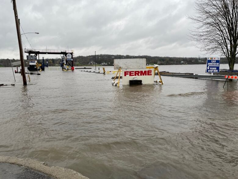 A flooded ferry dock with a closed sign.