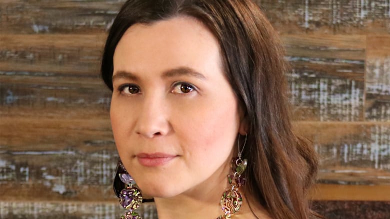 A portrait of an Indigenous woman with dark hair looking into the camera.