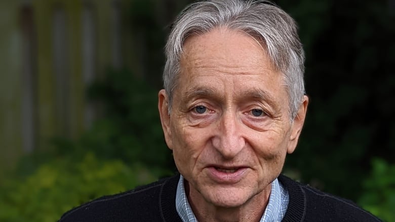 Portrait of a gray-haired man outside in a sweater.