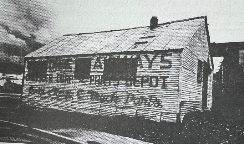 Black and white photo of an old building with 'Klondike Airways' written on the side.