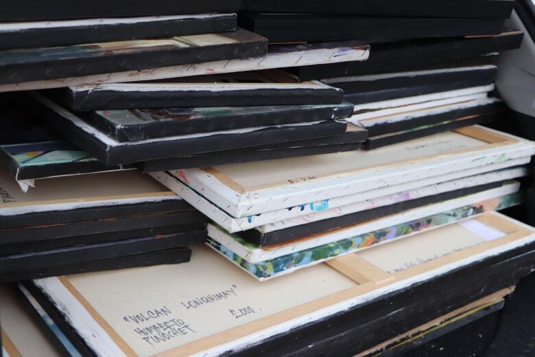 Dozens of canvases piled in the trunk of a car