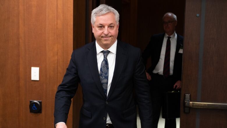 Director of the Canadian Security Intelligence Service (CSIS), David Vigneault smiles as he enters a room.