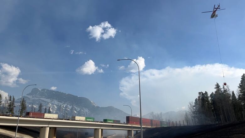 A helicopter is seen bucketing the fire near Banff Wednesday afternoon.