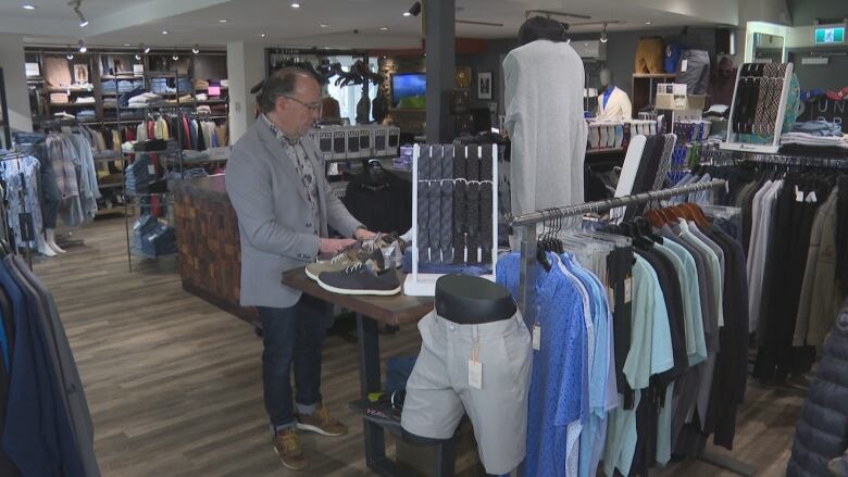 Man standing in a retail clothing store.