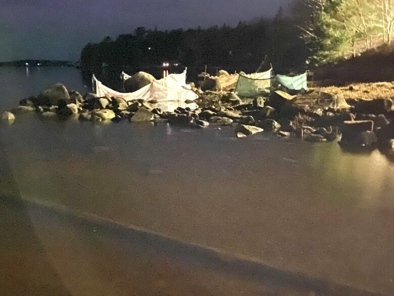 Nets and lights near a river at night.