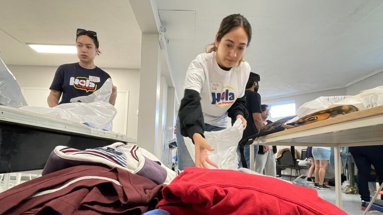 Volunteers sort clothing donations in an old church basement