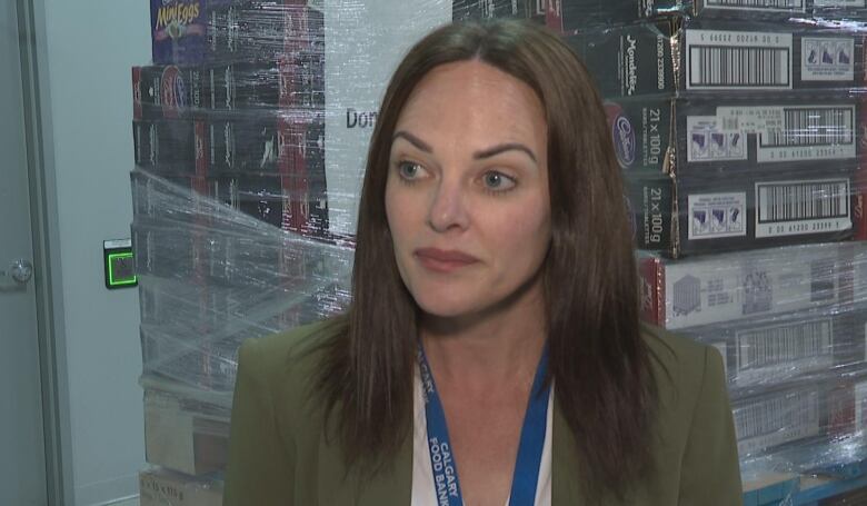 A woman in a green blazer. She has dark brown hair. 