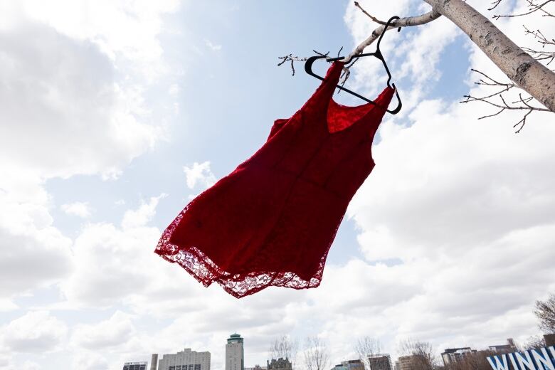 A red dress on a hanger blows in the wind.