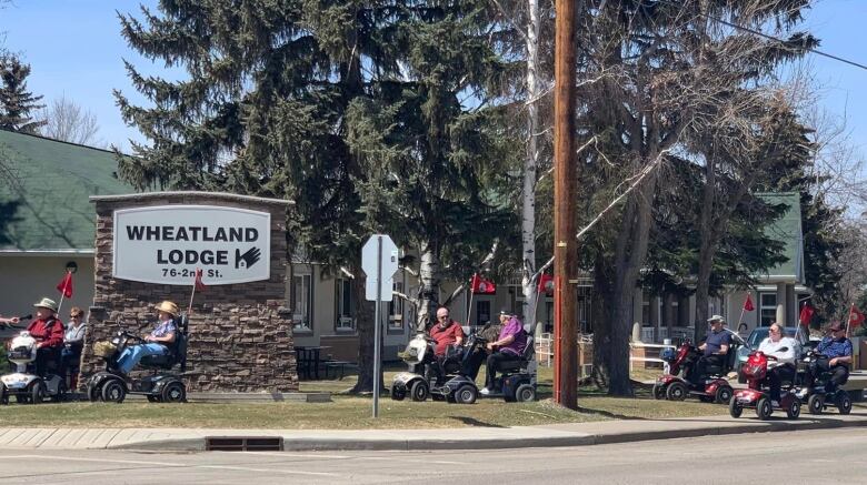 A group of people on mobility scooters.