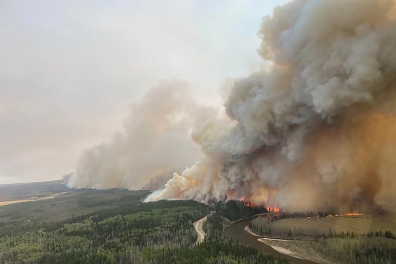 Smoke billowing over river.