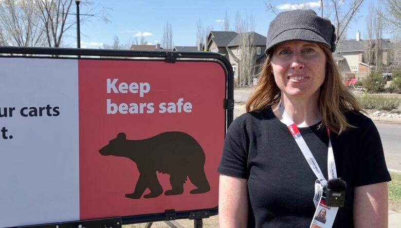 Erica Baranik is pictured standing next to a new sign reminding people in Discovery Ridge to be more aware of the link between their garbage and bears.