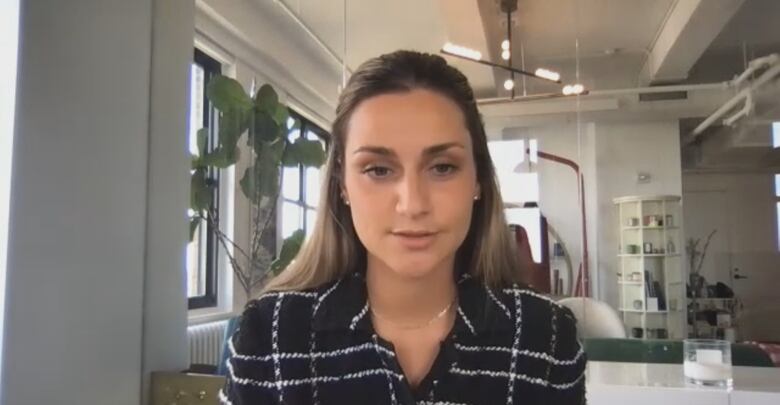 A woman in front of a Zoom camera in an office. 