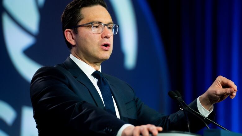 A politician gestures while giving a speech.