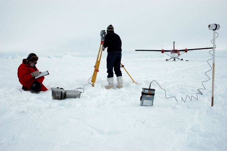 Two Arctic researchers working in the snow.