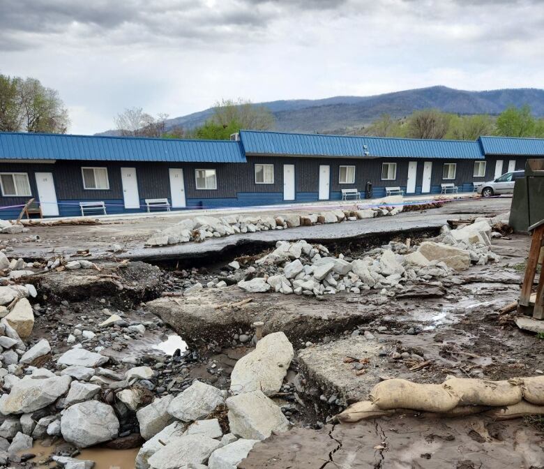 A damaged road with a lot of debris and mud.