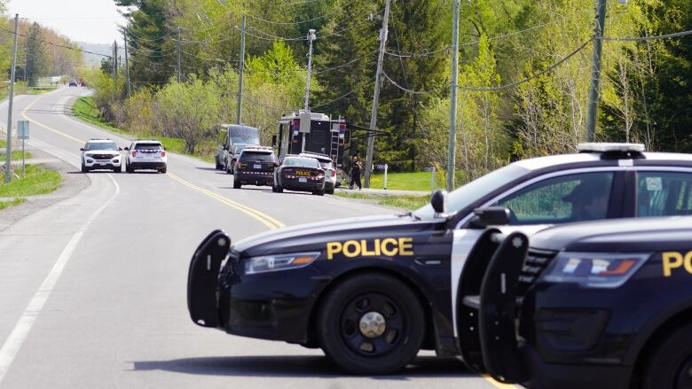 Police vehicles blocking a road.