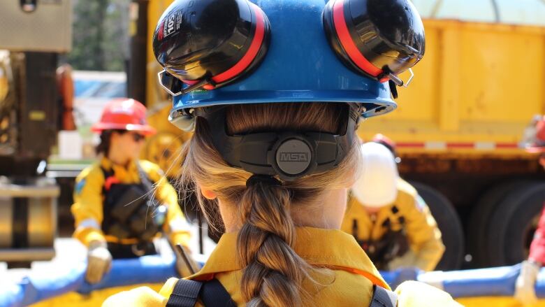 The back of a person's head, wearing a blue helmet.