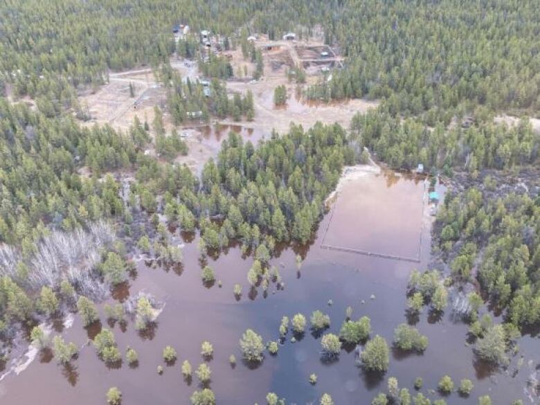 An aerial image shows water overwhelming a large property.