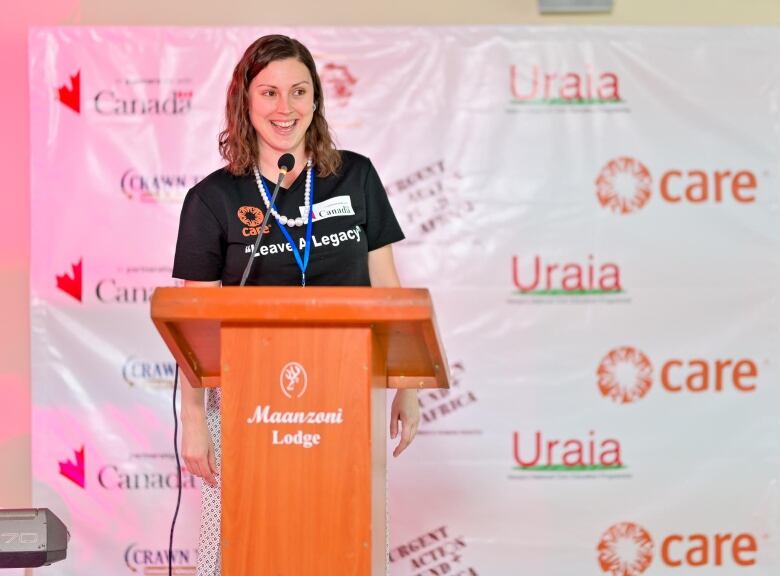 Florence Allard-Buffoni speaks into a mic at a CARE event