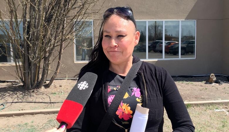 A woman smiles at a reporter behind a camera.