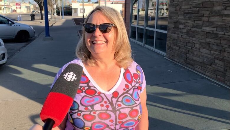 A woman smiles at a reporter behind the camera. 